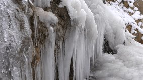 Many crowded icicles cover a natural frozen waterfall in cold air during winter. Winter conditions create dense ice formations as water freezes into clustered shapes. - Powered by Shutterstock - Get 15% off with code: PIKWIZARD15
