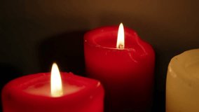 Three pillar candles glowing, gold confetti appearing from above and drifting down for celebration. Wax, flame, trio, closeup, tabletop, interior, warm - Powered by Shutterstock - Get 15% off with code: PIKWIZARD15