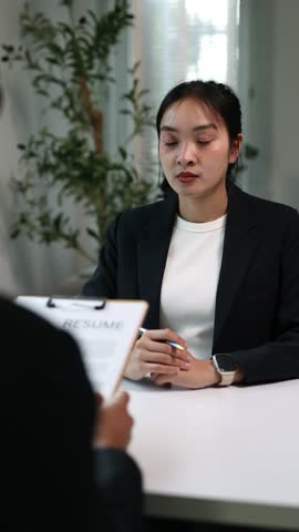 Young businesswoman giving resume to hiring manager during job interview, recruitment concept.