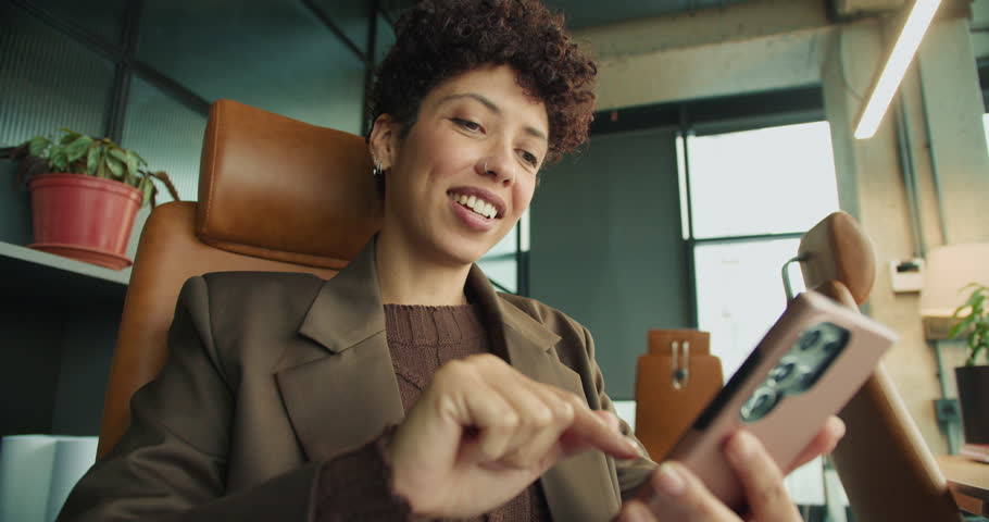 Cheerful female enjoying content creation in lively workspace