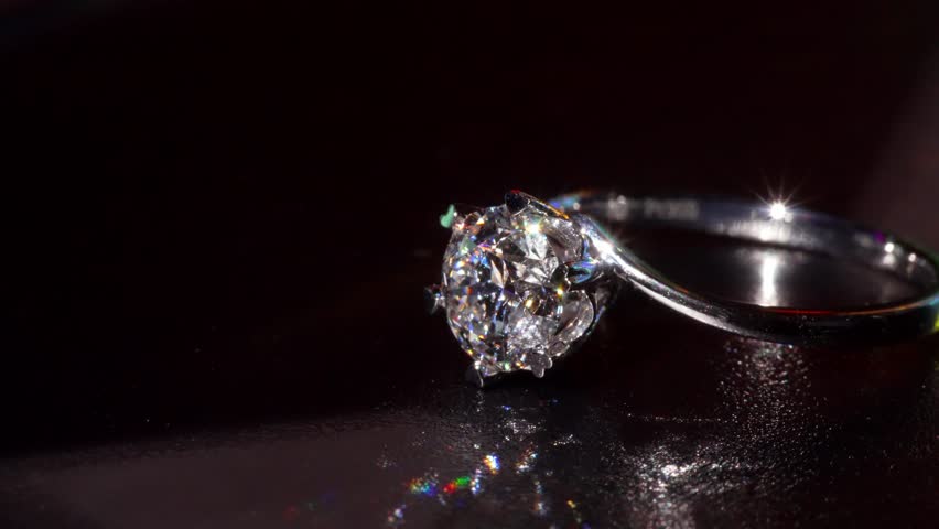 Brilliant Diamond Gold Ring Shines in Dramatic Macro Close-Up. Revealing Its Sparkling Facets Refined Metalwork. Luxurious Blend of Artistry, Elegance and Timeless Beauty In Every Glowing Detail 4k