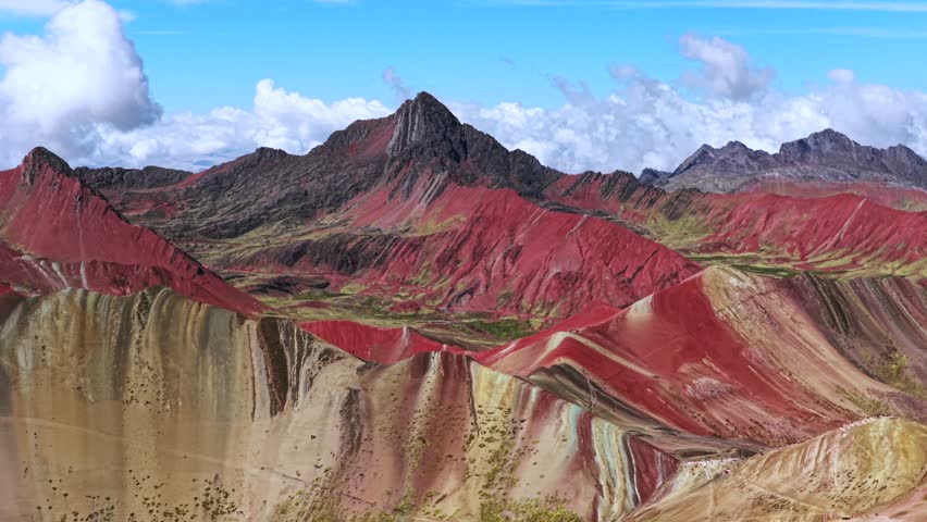 Vinicunca Rainbow Mountain Peru Perú aerial drone morning blue sky Montaña de Siete Colores Palccoyo clouds Peruvian Andes Red Valley striped hills seven colored Cusco Region landscape parallax circle