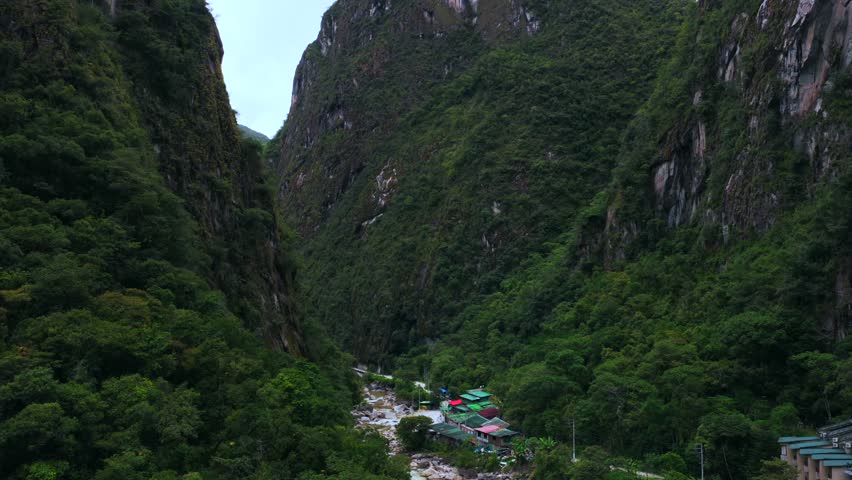 Aguas Calientes Machu Picchu dry rainy season cloudy afternoon Peru aerial drone Urabumba river jungle hillside Peruvian Andes Mountains lower highlands Inca trail citadel nature landscape buildings