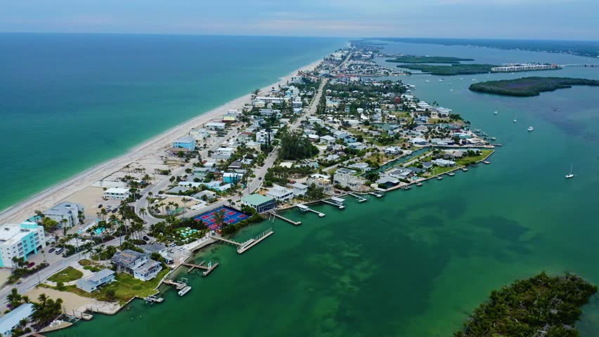 Waterfront homes and docks line the narrow stretch of Manasota Key as boats anchor in green channels of Lemon Bay, bordered by mangrove islands and the Gulf shoreline along Florida’s southwest coast.