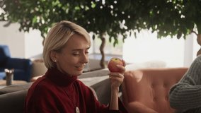 Two diverse colleagues enjoying friendly conversation during lunch break in bright modern office, highlighting teamwork connection and relaxed workplace atmosphere - Powered by Shutterstock - Get 15% off with code: PIKWIZARD15