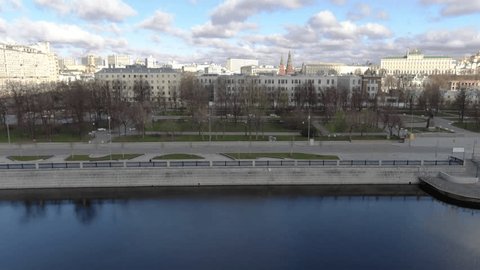 Drone Gliding Diagonally across Quiet Riverbank
