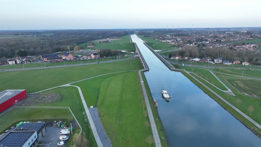 Aerial zoom in showing a boat navigating the elevated canal of Strépy-Thieu in Le Roeulx during golden hour