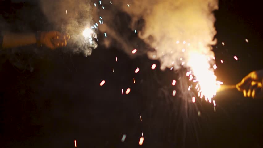 Group of friends having fun with sparklers during New Year celebration. Concept of joy, celebration and togetherness. Diwali and Christmas background. Diwali Festive and vibrant atmosphere. 