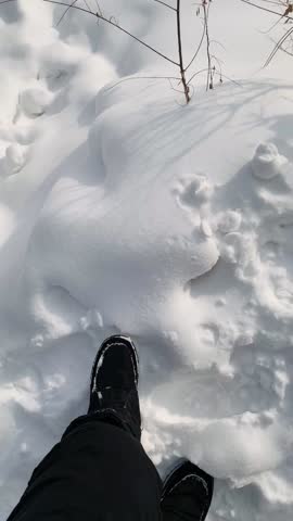 Woman feet wearing boots walking on the snow ground on a Winter and snow background of a countryside at Snow Valley, China 