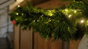 Closeup festive garland, golden bow, warm fairy lights on pine. Shimmering red ornament hanging against wooden wall. Cozy Christmas scene. Warm holiday ambiance. Glowing ornaments. Celebratory decor - Powered by Shutterstock - Get 15% off with code: PIKWIZARD15