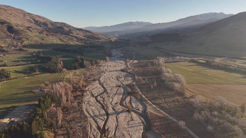 Backward drone flight over the dry riverbed of the Wanaka River in New Zealand's South Island.