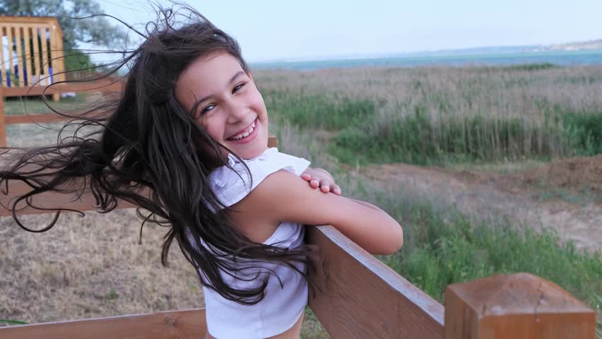 A thoughtful young girl with her hair blowing in the wind
