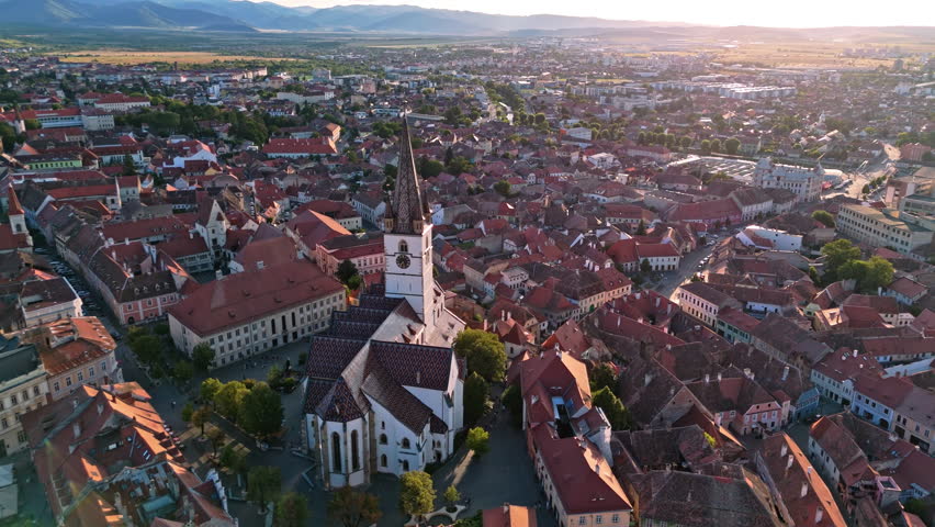 Aerial view of Sibiu historic center with churches and red roofs at sunset