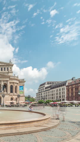 Hyperlapse of the Alte Oper (Old Opera) house in Frankfurt, a concert hall in Opernplatz. The square features a central fountain with people walking around, highlighting historic landmark timelapse