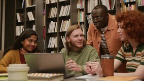 Multi ethnic group of smiling college students discussing homework assignment browsing information on laptop while studying together in library - Powered by Shutterstock - Get 15% off with code: PIKWIZARD15