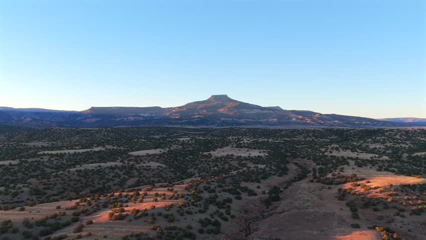 Stunning view focusing on the expansive, scrub-covered terrain leading up to Cerro Pedernal. This classic New Mexico view, including Abiquiu Lake shoreline, was a key subject for Georgia O