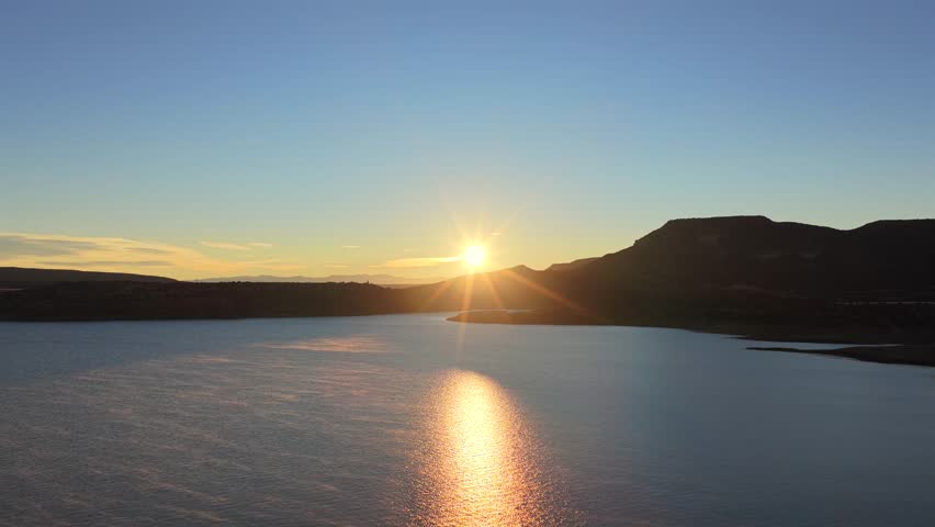The serene water meets the dry, rugged shoreline of Abiquiu Lake. This reservoir is a central feature of the famous New Mexico landscape painted by Georgia O