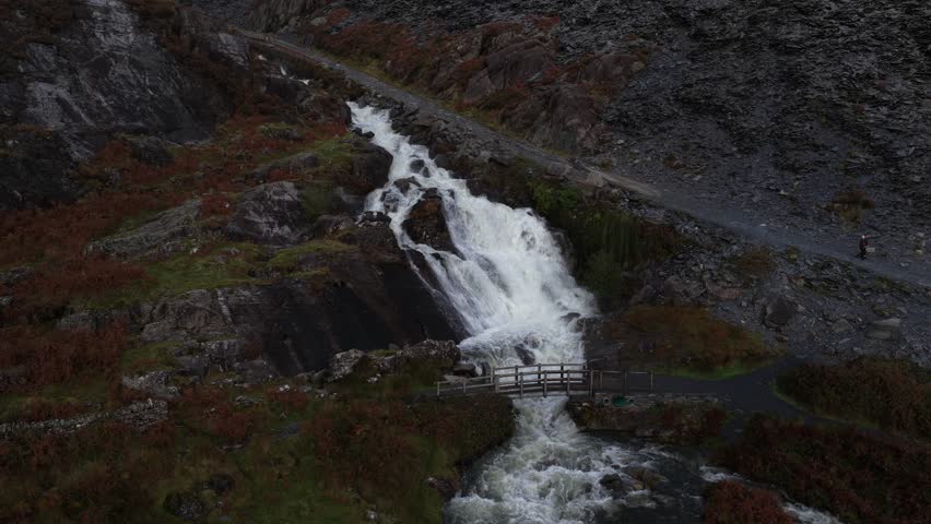 Aerial video of the Cwmorthin Waterfall at the historic Cwmorthin Quarry in Snowdonia National Park, showcasing rugged Welsh terrain, cascading water, and dramatic natural scenery.