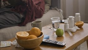Handheld shot of aged Caucasian sick man taking nap after reading book lying on sofa next to table with medication in living room - Powered by Shutterstock - Get 15% off with code: PIKWIZARD15