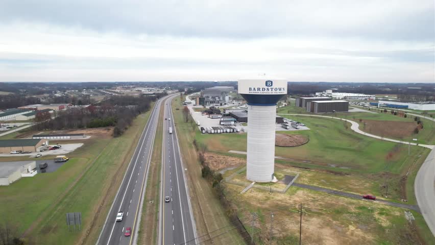 Aerial drone shot of the Kentucky Bluegrass Parkway with the Bardstown water tower in view. Scenic transportation and small-town identity.