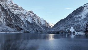 Klöntalersee Switzerland with calm winter lake, snowy mountains and soft morning light, drone view in Glarus region. - Powered by Shutterstock - Get 15% off with code: PIKWIZARD15