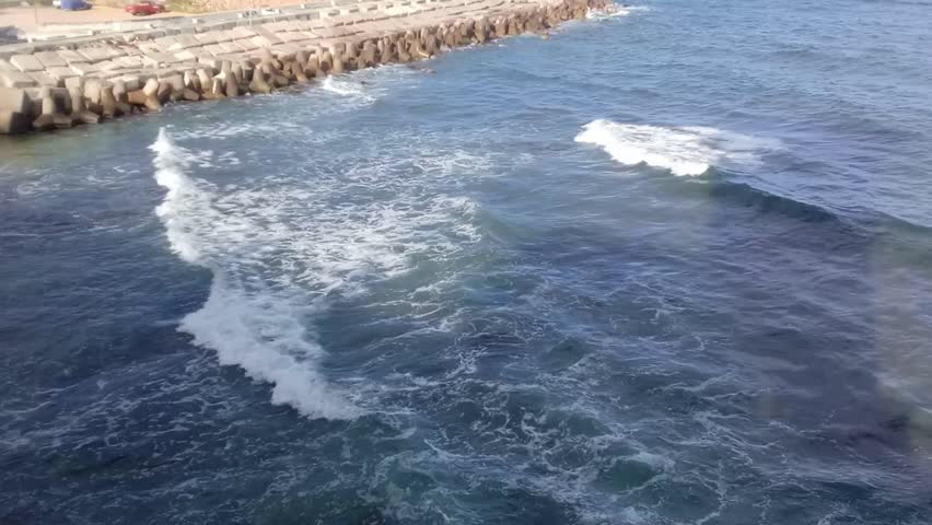 A great view of some rocks and the Mediterranean Sea is next to Stanley Bridge on the Corniche Road in Alexandria, Egypt. The bridge is 400 meters long. It has a pedestrian walkway.