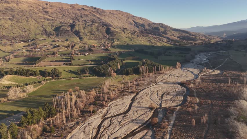 Drone flight over the dry Wanaka riverbed on the South Island of New Zealand during sunset.