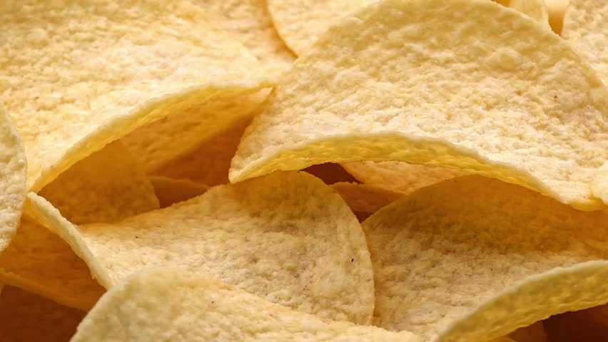 Crispy potato chips. Golden crunchy snack texture background