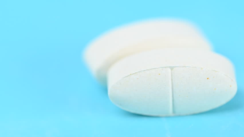Video of white pills on a blue background