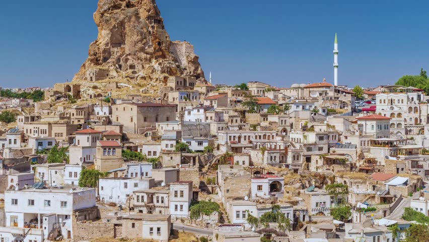 Aerial view of Cappadocia, Turkey, showcasing houses, unique rock formations, and the stunning landscape from above, highlighting the region’s natural and cultural beauty.