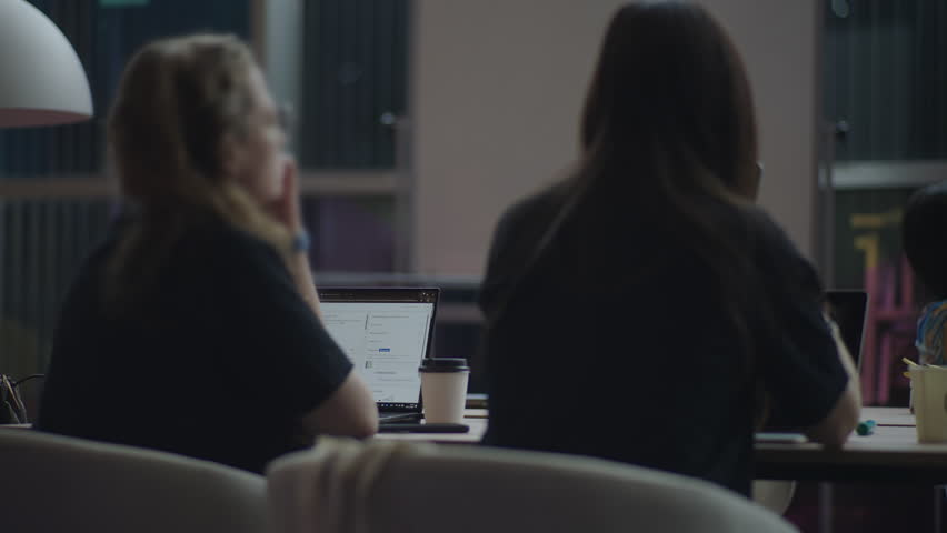 Footage of audience members attending talks at a tech event, listening, taking notes, and watching presentations. Ideal for conference promos and educational or business video projects.