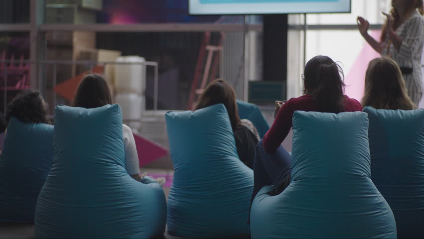 Footage of audience members attending talks at a tech event, listening, taking notes, and watching presentations. Ideal for conference promos and educational or business video projects.