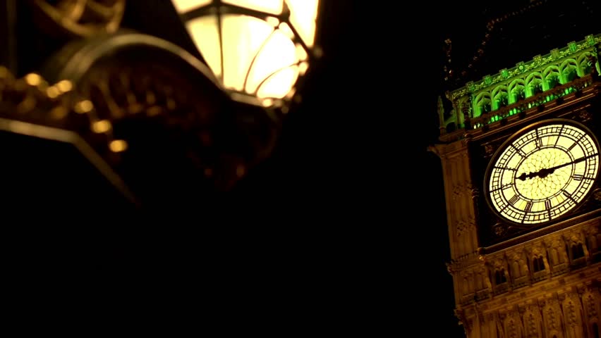 Located in London, iconic Big Ben stands tall at night, beautifully lit. A vintage lantern adds charm to scene, showcasing architectural marvel and vibrant city life.