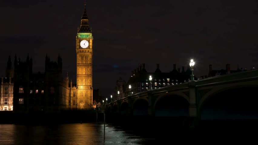 Majestic Big Ben stands tall against night sky, brilliantly lit in gold. River Thames flows gently, reflecting vibrant lights. Iconic London landmark on display after sunset.