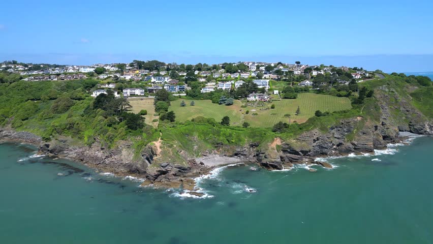 Torbay, Devon, England: The drone flies towards Thatcher Point on the coastline showing expensive properties overlooking the cliffs. Torbay is a popular UK holiday destination and retirement area as well as being a magnet for water sports enthusiasts.