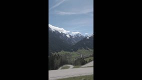 Neustift, Austria - April 19, 2025 - vertical scenic view of snow-capped mountains and a winding road on a sunny day - Powered by Shutterstock - Get 15% off with code: PIKWIZARD15