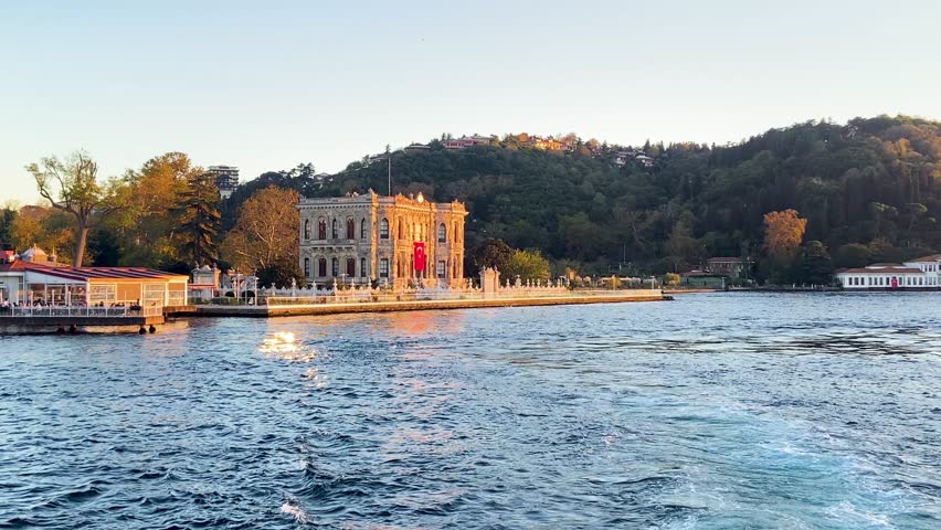 Cinematic slow motion view of the historical Kucuksu Pavilion on the Bosphorus coast with calm sea in Istanbul, Turkey.