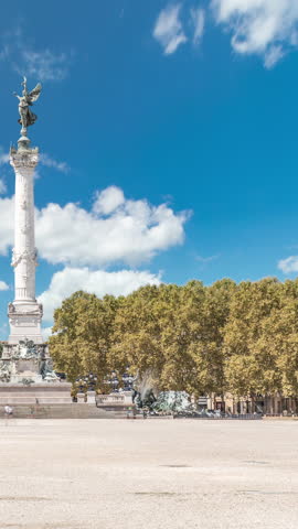 Monument Aux Girondins with fountain on Esplanade Des Quinconces timelapse in Bordeaux, France. Historic landmark and architectural masterpiece symbolizing liberty and revolution. Blue cloudy sky