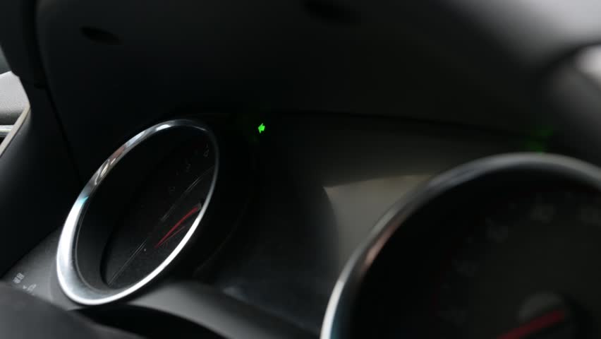 Close-up video of a car dashboard with the left turn signal blinking, accompanied by the clicking sound of the indicator