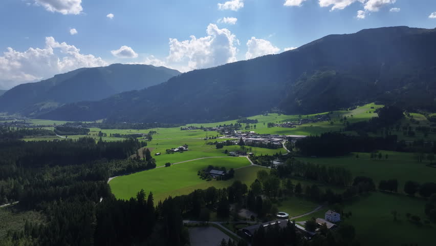 aerial patchwork fields in sunlit valley, scattered farms and barns, rolling hills, irrigation patterns, long shadows, distant