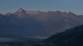 alpenglow kisses jagged mountain summits with warm pink light while valley remains cool and shadowed, cinematic aerial shot - Powered by Shutterstock - Get 15% off with code: PIKWIZARD15