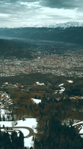 Aerial shot of Grenoble and surrounding Alps in winter, France. View to the east from the Vercors mountain range, vertical video