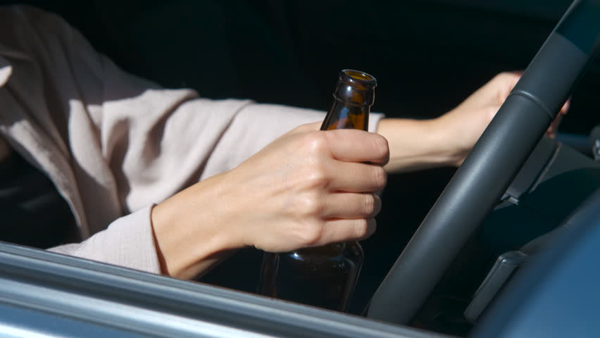 Woman drinking beer while driving montage. Reckless female driver consuming alcoholic beverage while operating vehicle, highlighting dangerous illegal behavior and potential road safety risks