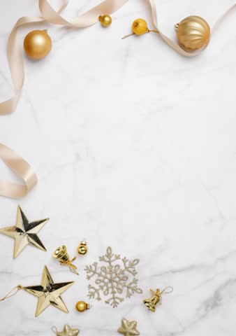 A luxurious and modern Merry Christmas greeting video featuring gold ornaments, ribbons, and star decorations on a bright white marble background.