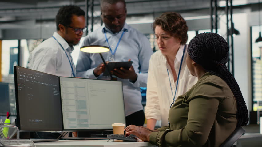 Team of software developers in office working together, automating workflows using AI. IT experts brainstorming to refine deep learning computational models for faster processing, camera B