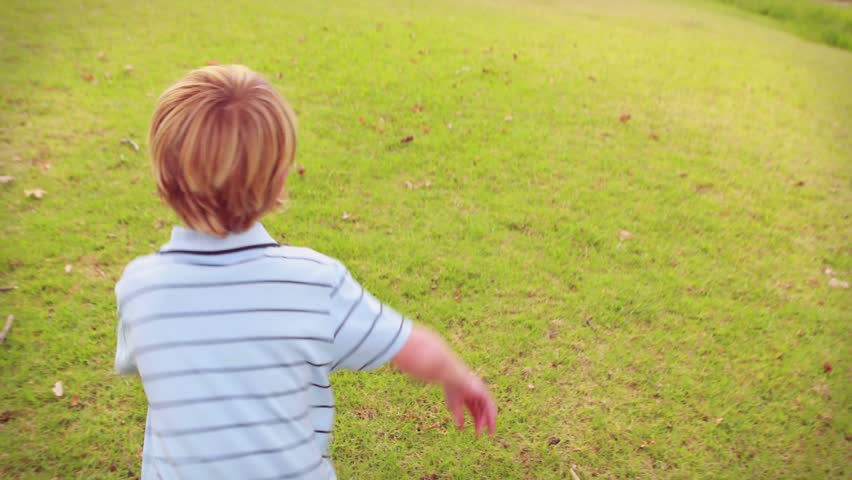 Boy running toward swing on seeing swing, seeking play, red hearts growing across front marketing. Kid, outdoor, lawn, grass, tree, rope, flowers