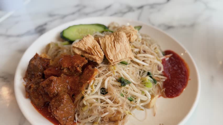 A plate of vegetarian mee hoon noodles served with flavourful mock mutton at a Malaysian restaurant in New Zealand. 