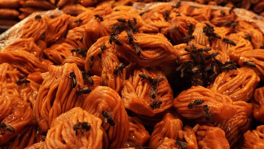Many bees on Moroccan pastries searching for sugar or honey.