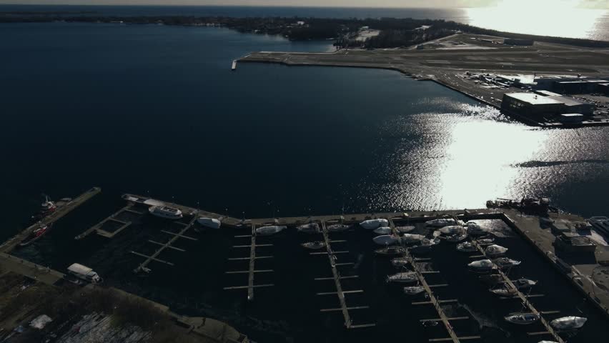 Drone Aerial of Toronto Coastal Waterfront Skyline at Midday featuring the CN Tower, Rogers Centre, Harbourfront, and the shoreline of Lake Ontario.
