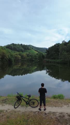 Person With Bicycle Looking at Lake View